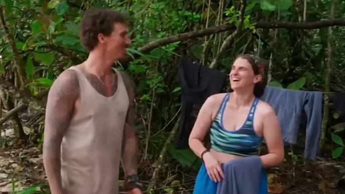 Two people standing in the jungle and laughing